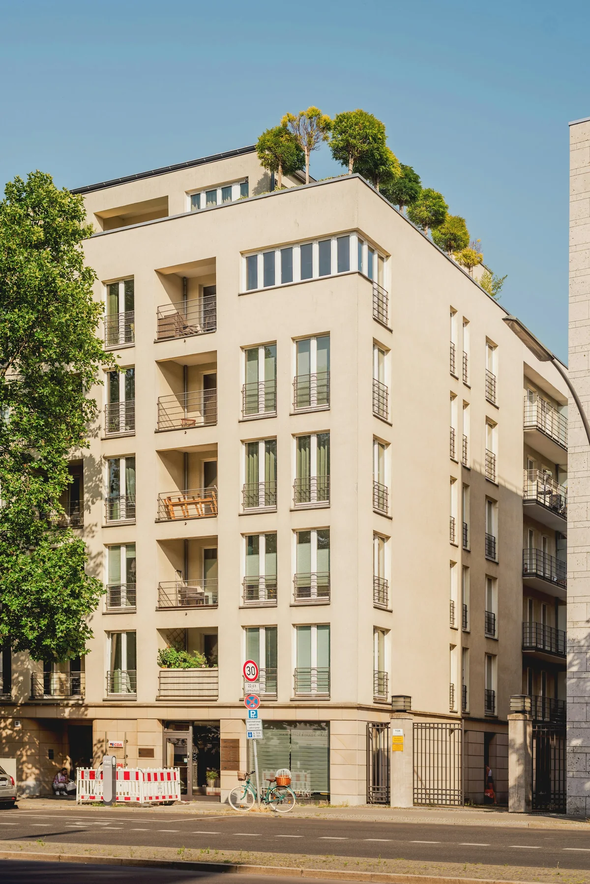 Helles Mehrfamilienhaus mit begrünten Dachterrassen und Balkonen – Symbolbild zur Hausverwaltung